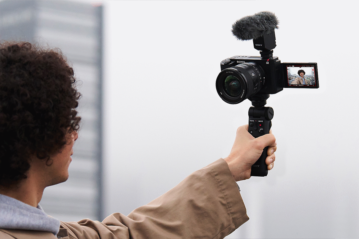 Hình ảnh người đàn ông đang chụp selfie bằng báng tay cầm gắn với máy ảnh
